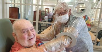 Aged care provider comes up with COVID-safe way to help residents and family interact – a hugging station